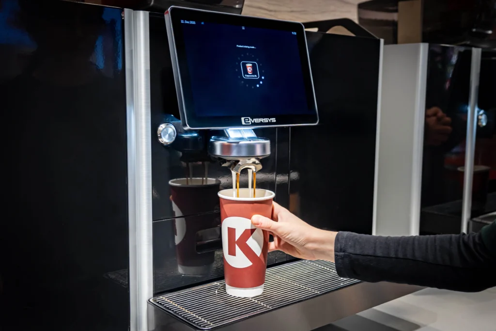 Modernus kavos aparatas pilantis gėrimą į „Circle K“ puodelį.