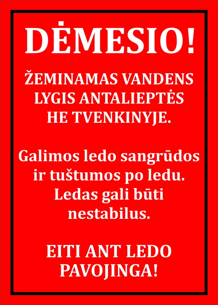 Raudonas įspėjamasis plakatas su baltu tekstu, perspėjantis apie pavojingą ledą ir žeminamą vandens lygį Antalieptėje.