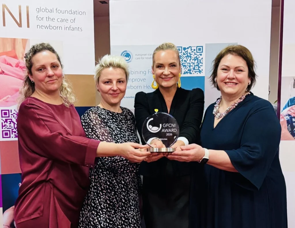 Keturios moterys laiko stiklinį „GFCNI Award 2024“ apdovanojimą.