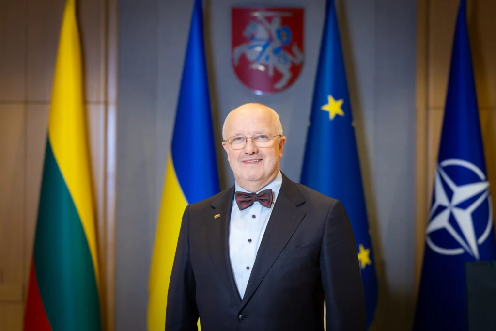 Arvydas Anušauskas stovi priešais Lietuvos, Ukrainos, ES ir NATO vėliavas.