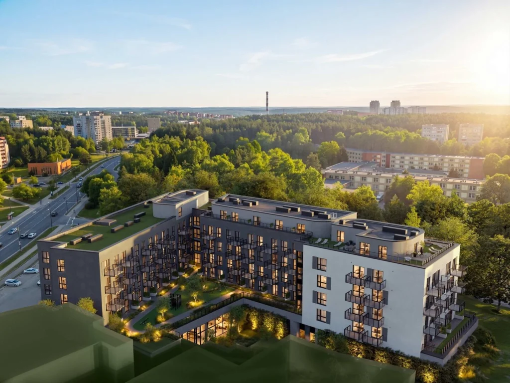 Šiuolaikinis daugiabučių projektas apsuptas žalumos vakaro šviesoje.