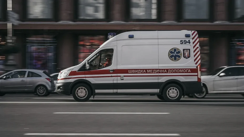 Skubančio greitosios medicinos pagalbos automobilio vaizdas gatvėje, perspėjantis vairuotojus dėl teisingo elgesio kelyje.