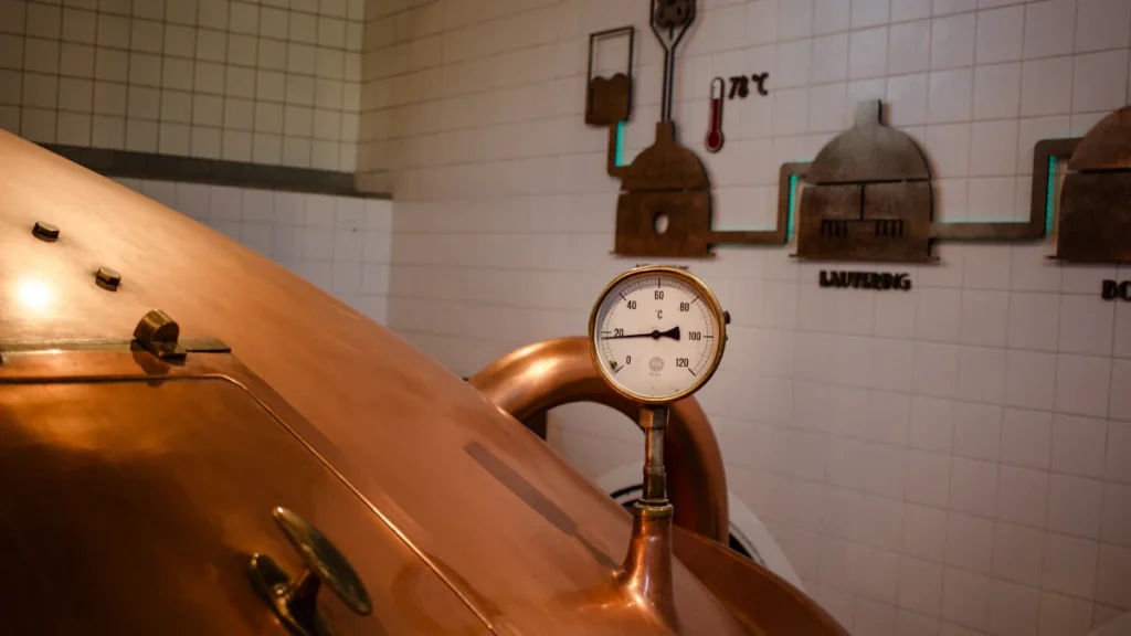 Varinis alaus virimo katilas su temperatūros matuokliu modernioje gamybos darykloje.