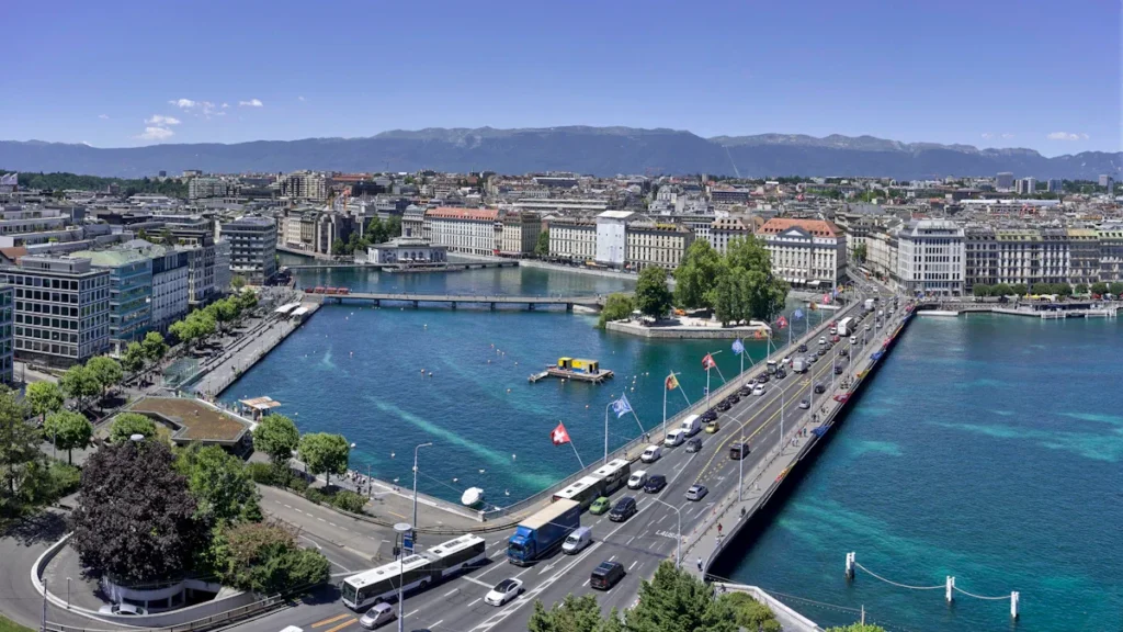 Iš viršaus užfiksuotas Ženevos miesto vaizdas, Monblano tiltas ir Ženevos ežeras giedrą dieną.