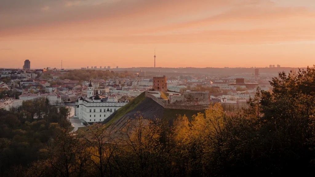 Panoraminis Vilniaus senamiesčio vaizdas su Gedimino pilies bokštu gražiame saulėlydžio apšvietime.