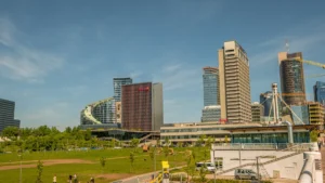 Vilniaus verslo kvartalas su dangoraižiais, matomas iš šalia esančio parko giedrą dieną.