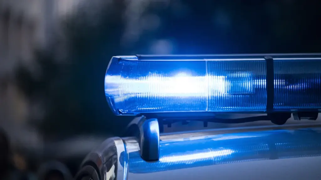 Mėlyni švyturėliai ant policijos automobilio stogo, įjungti operatyvinio reagavimo metu mieste.