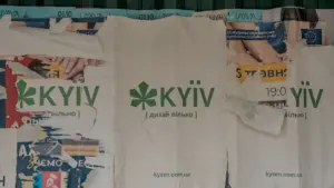 Antikvariniai plakatai su Kyjivo miesto simbolika pritvirtinti prie sienos Ukrainos sostinėje.