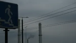Vilniaus pramoninė zona su dūmtraukiais niūrią dieną po perėjos ženklu