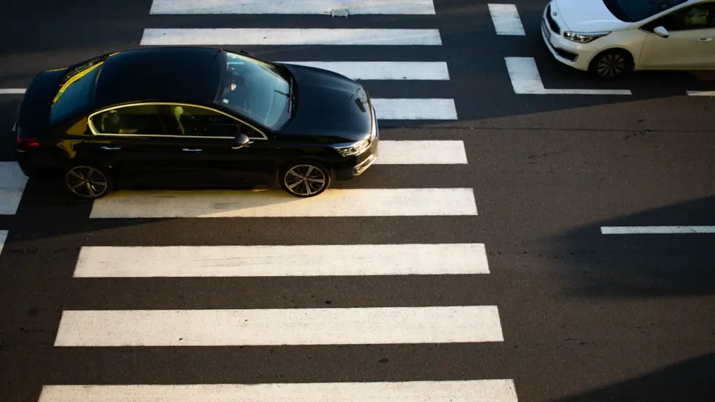 Automobilis kertantis pėsčiųjų perėją, simbolizuojantis saugumą kelyje moksleiviams rugsėjo mėnesį Kėdainiuose.