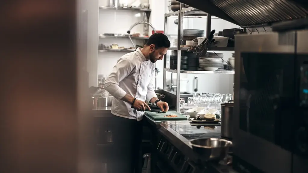Šefas profesionalioje virtuvėje ruošia maistą gastronominio turizmo strategijos kūrimui ir plėtrai.