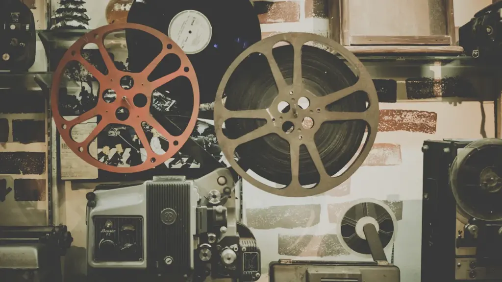 Senovinis kino projektorius su kino juostų ritėmis ir estetiška namų aplinka